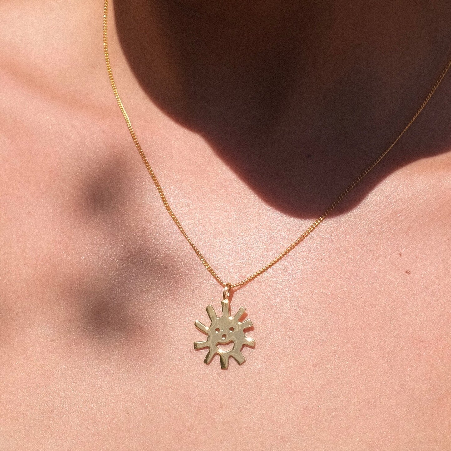 Close up of gold Smiley Sun Necklace