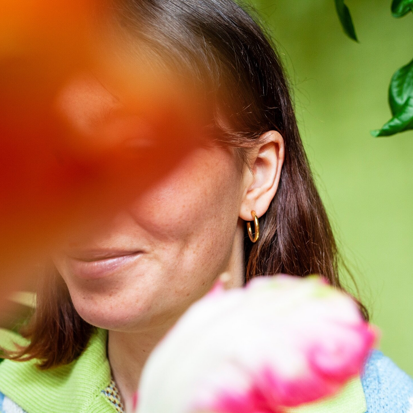 Woman wearing  small gold hoop earring