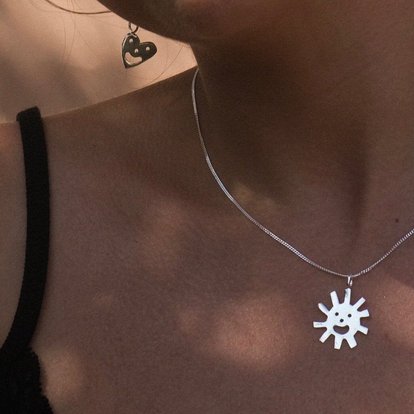 Close up of silver Smiley Sun Necklace