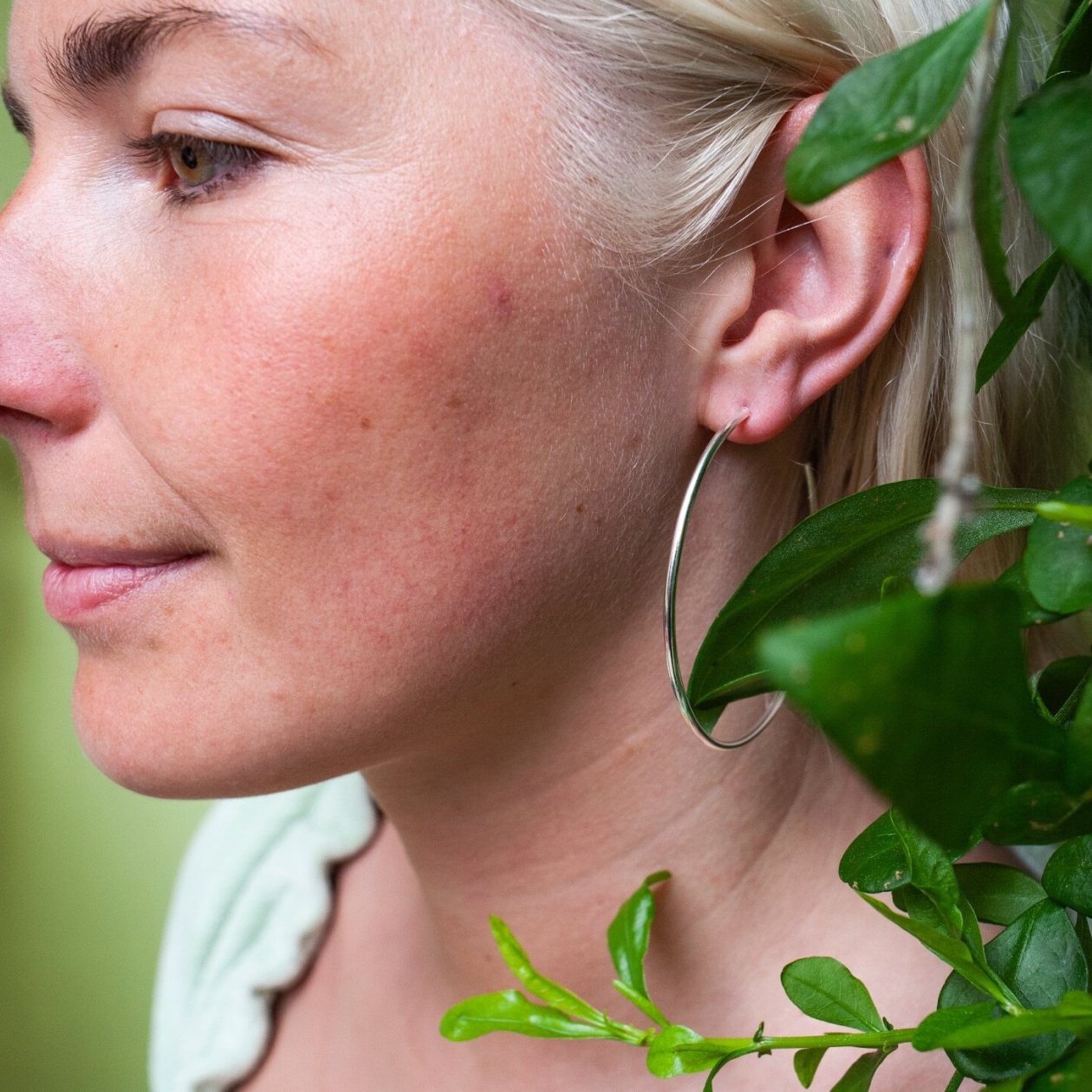 Woman wearing large silver hoop earring