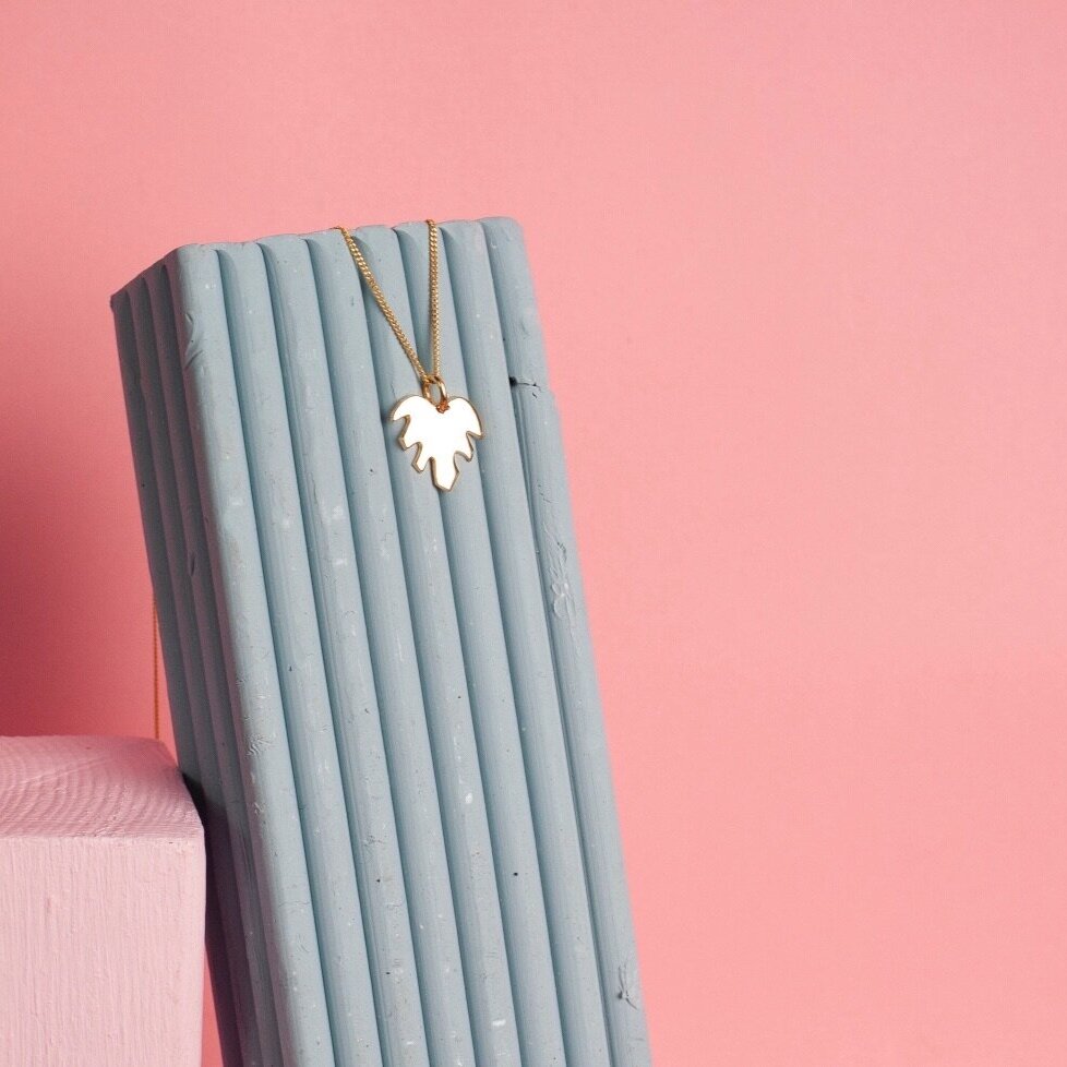 Pendant necklace with a gold leaf shape charm on it