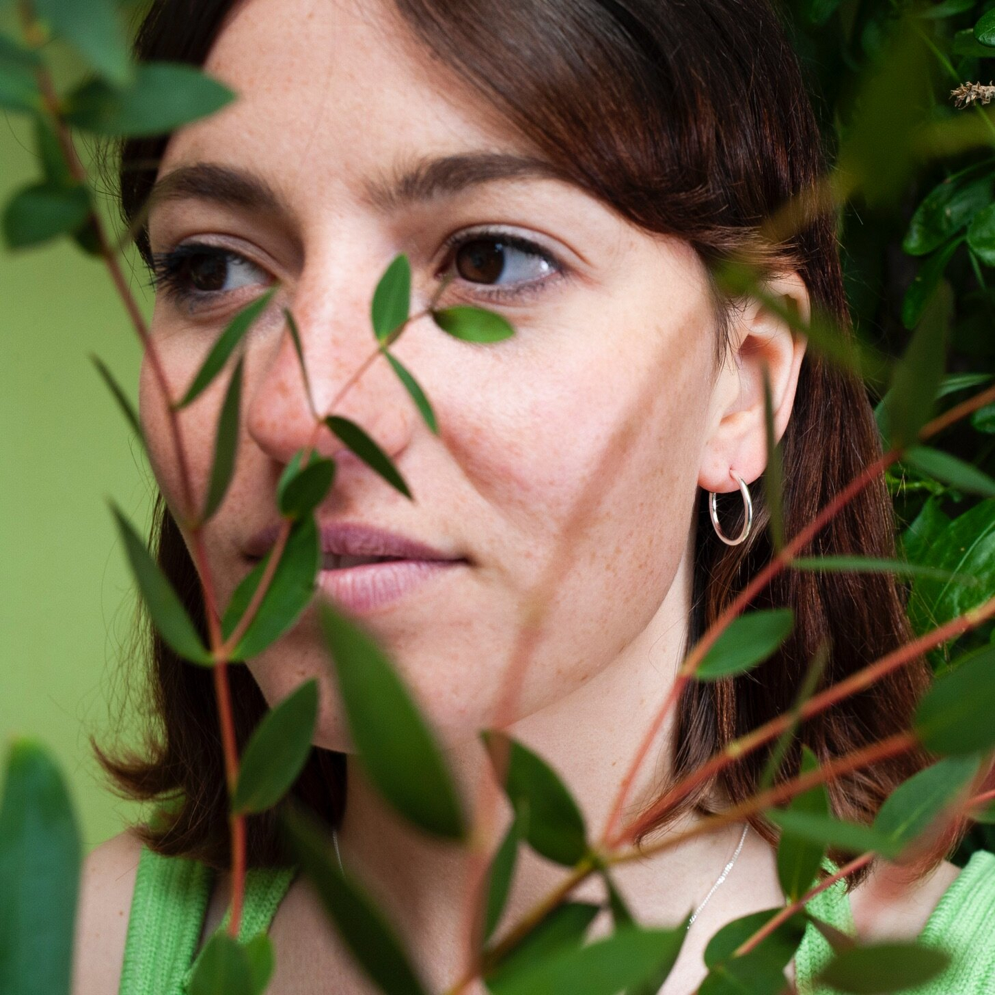 Close up of woman wearing small silver hoop earring