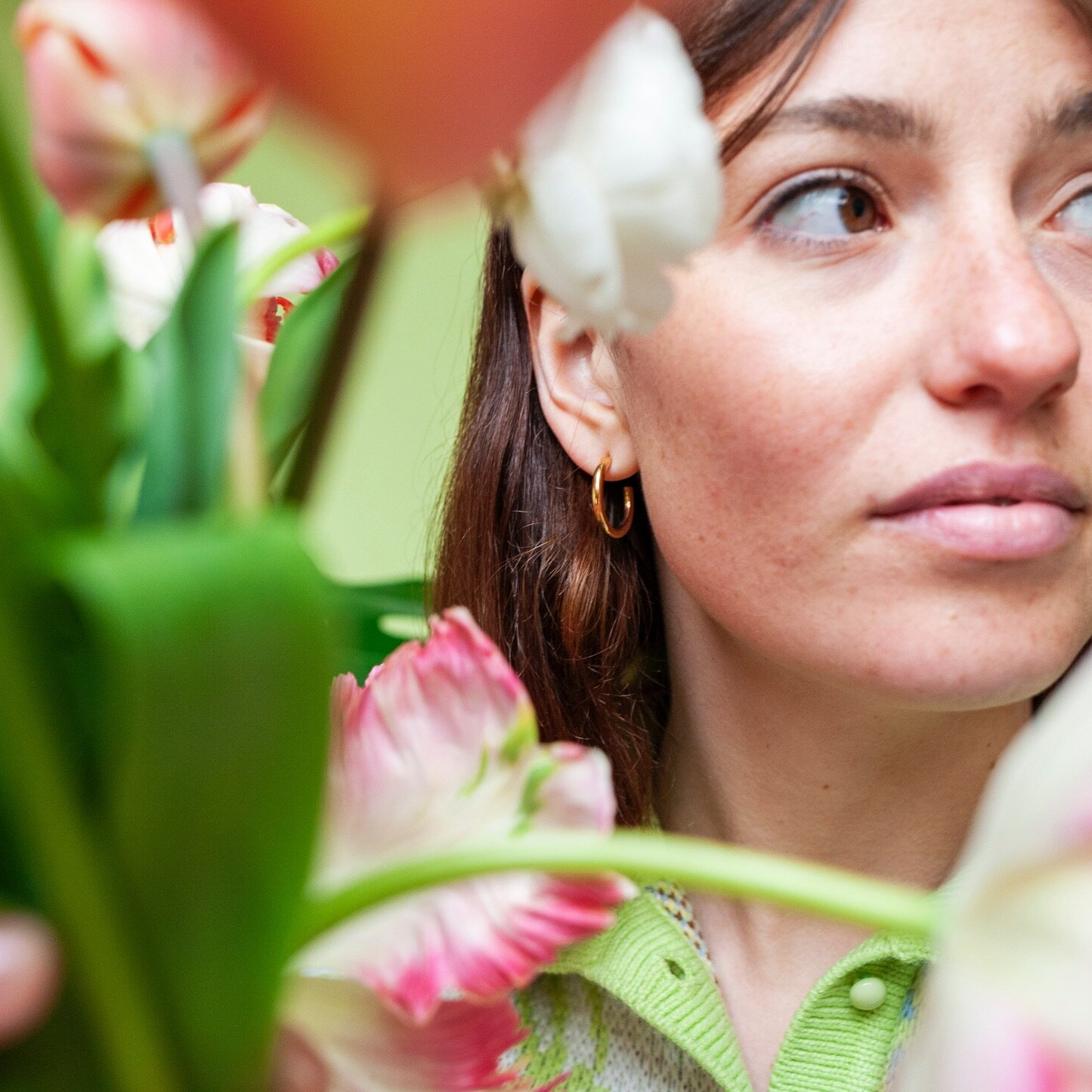 Close up of woman wearing small gold hoop earring