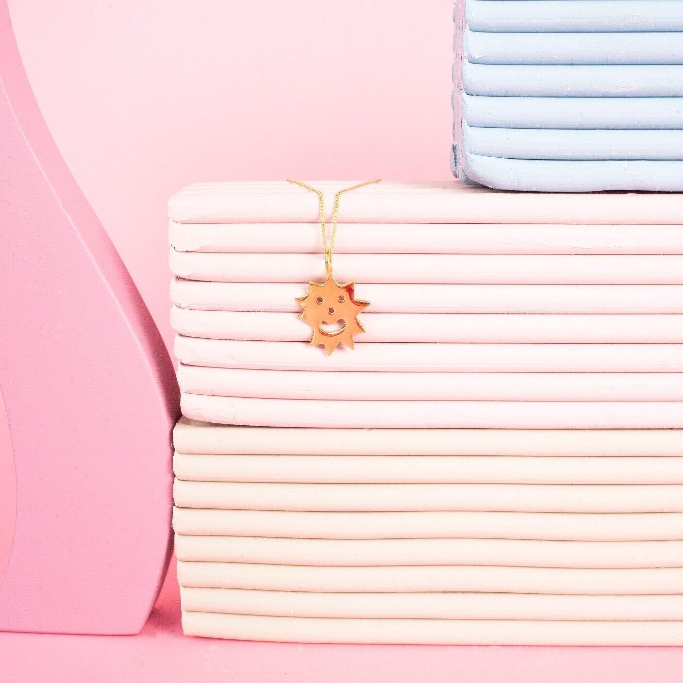 Pendant necklace with a spiky irregular shaped charm with a smiley face on