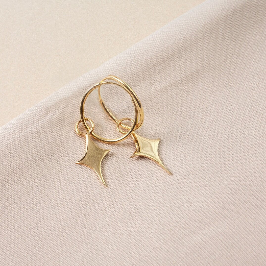 Small gold hoop earrings with a star shaped charm