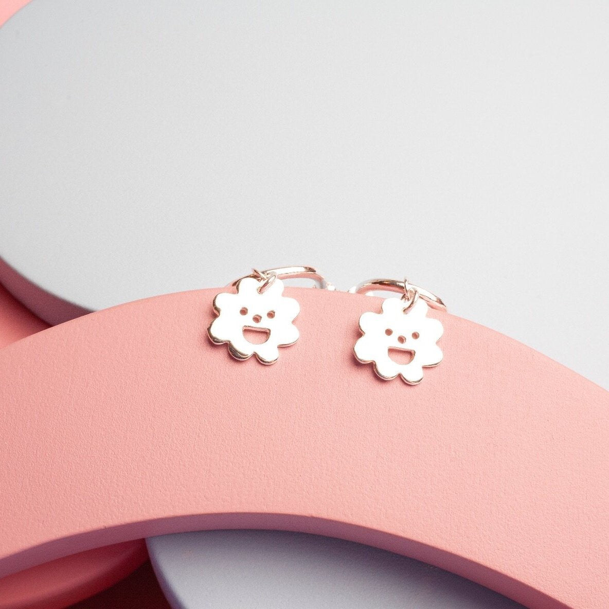 Close up of gold Smiley Flower Hoops earrings