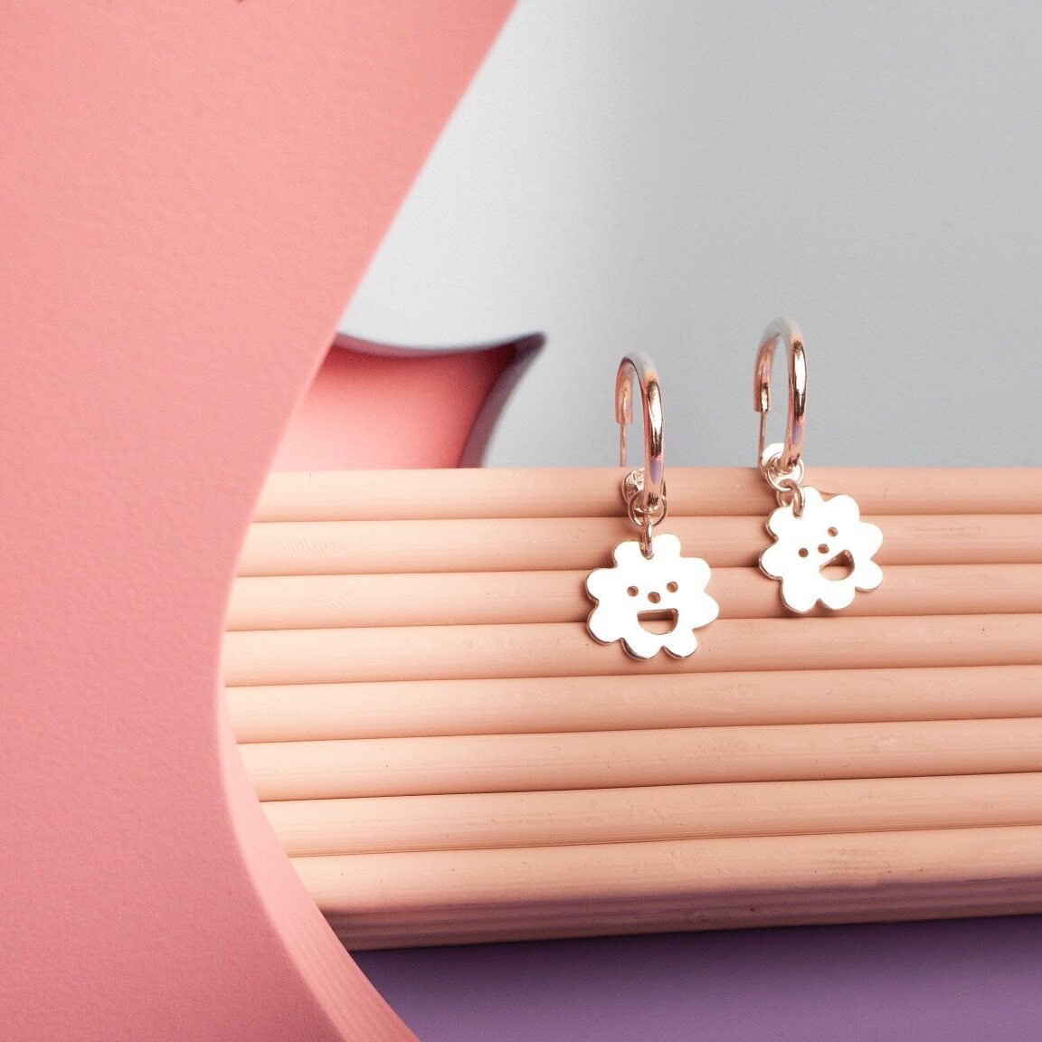 Close up of gold Smiley Flower Hoops earrings