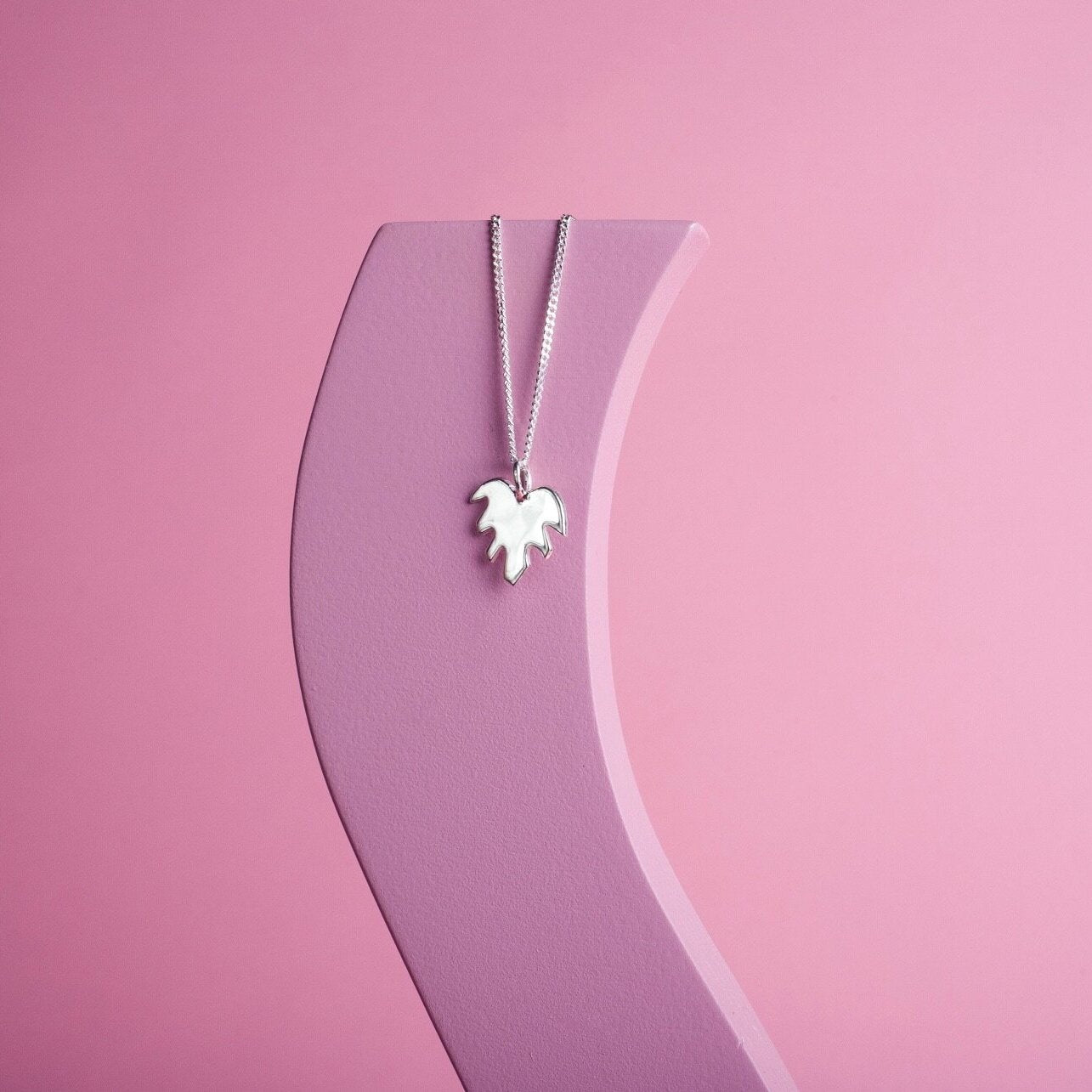 Pendant necklace with a silver leaf shape charm on it