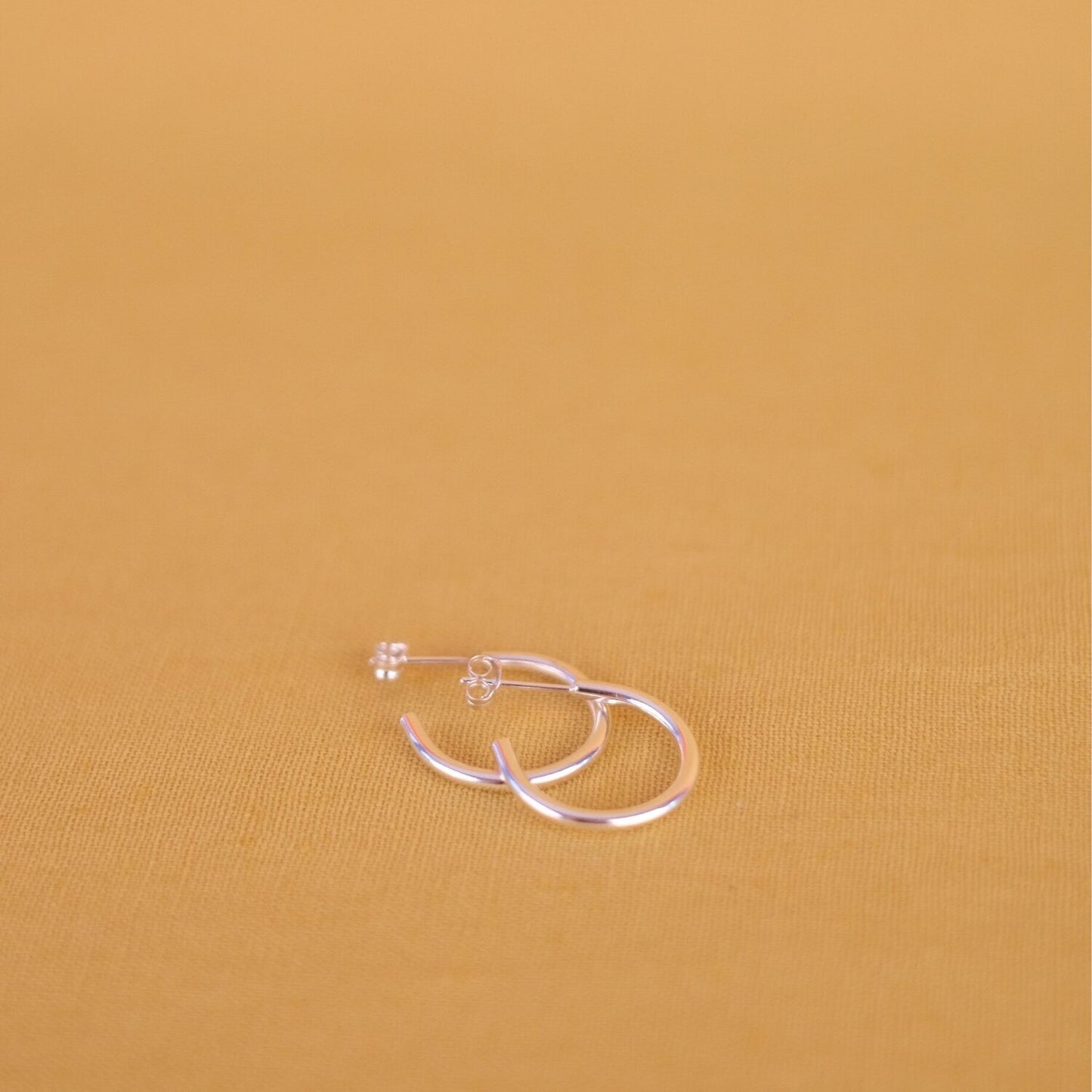 Close up of small silver hoop earrings