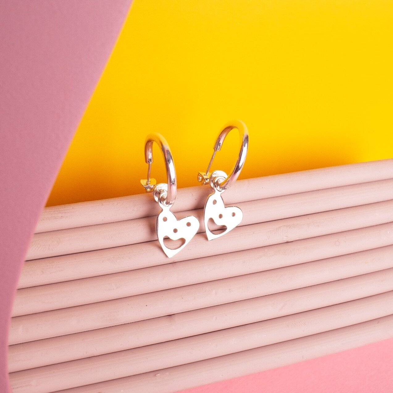 Close up of silver Smiley Heart Hoops earrings