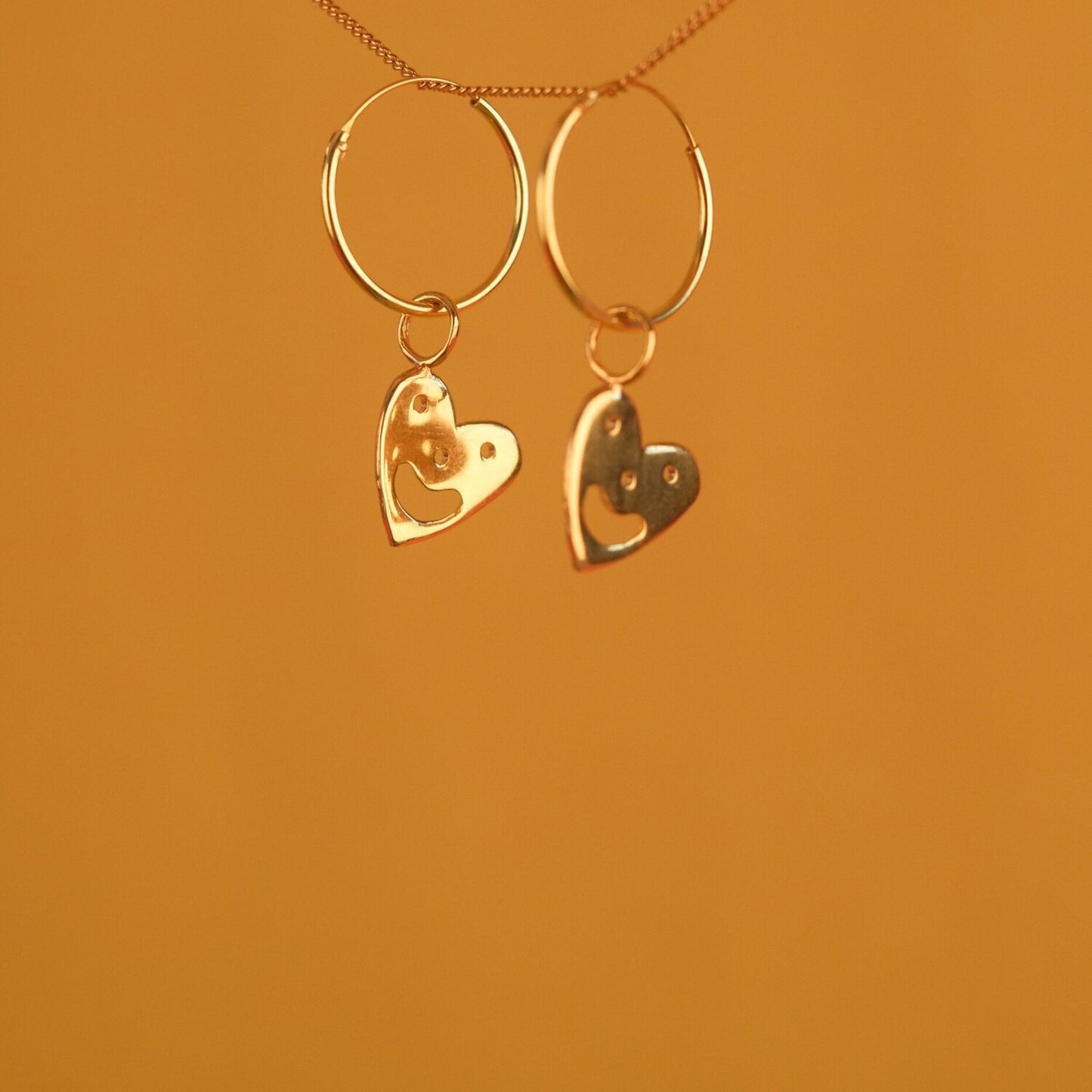 Close up of gold Smiley Heart Hoops earrings