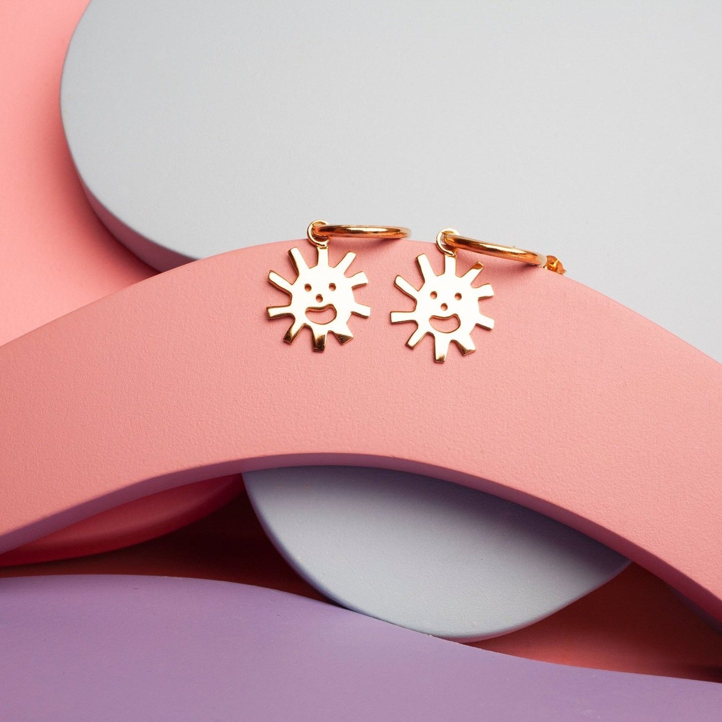 Close up of gold Smiley Sun Hoops earrings