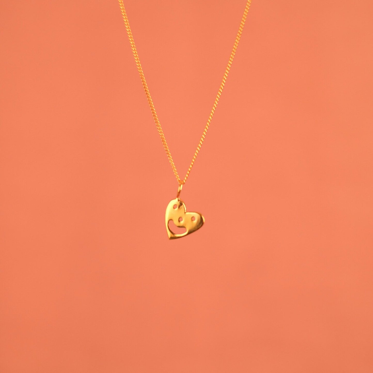 Pendant chain necklace with a smiling heart charm