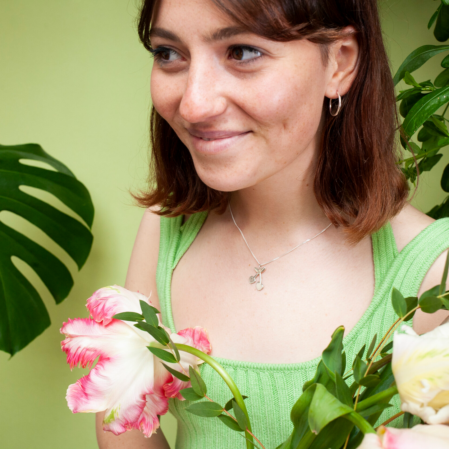Woman wearing gold pendant necklace with a cherry shaped charm