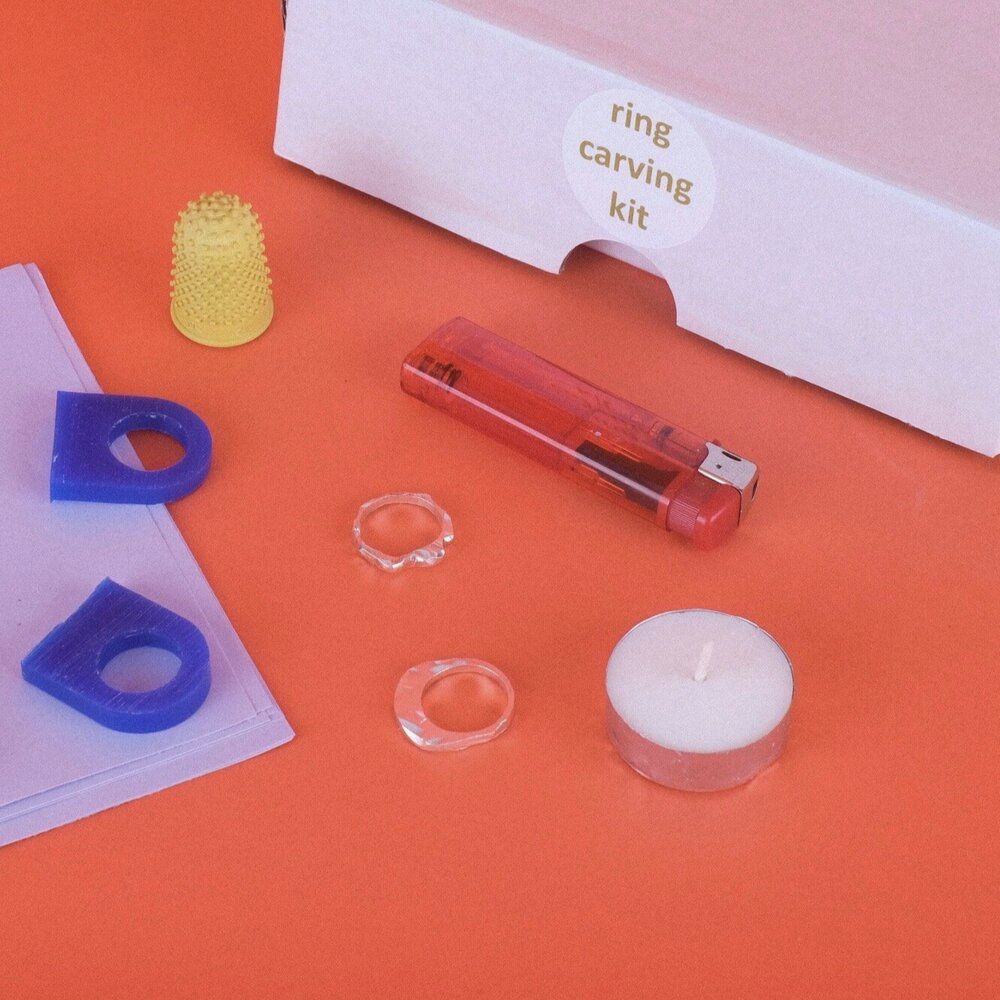 Contents of a ring carving kit, including lighter, tea light, wax, and tools
