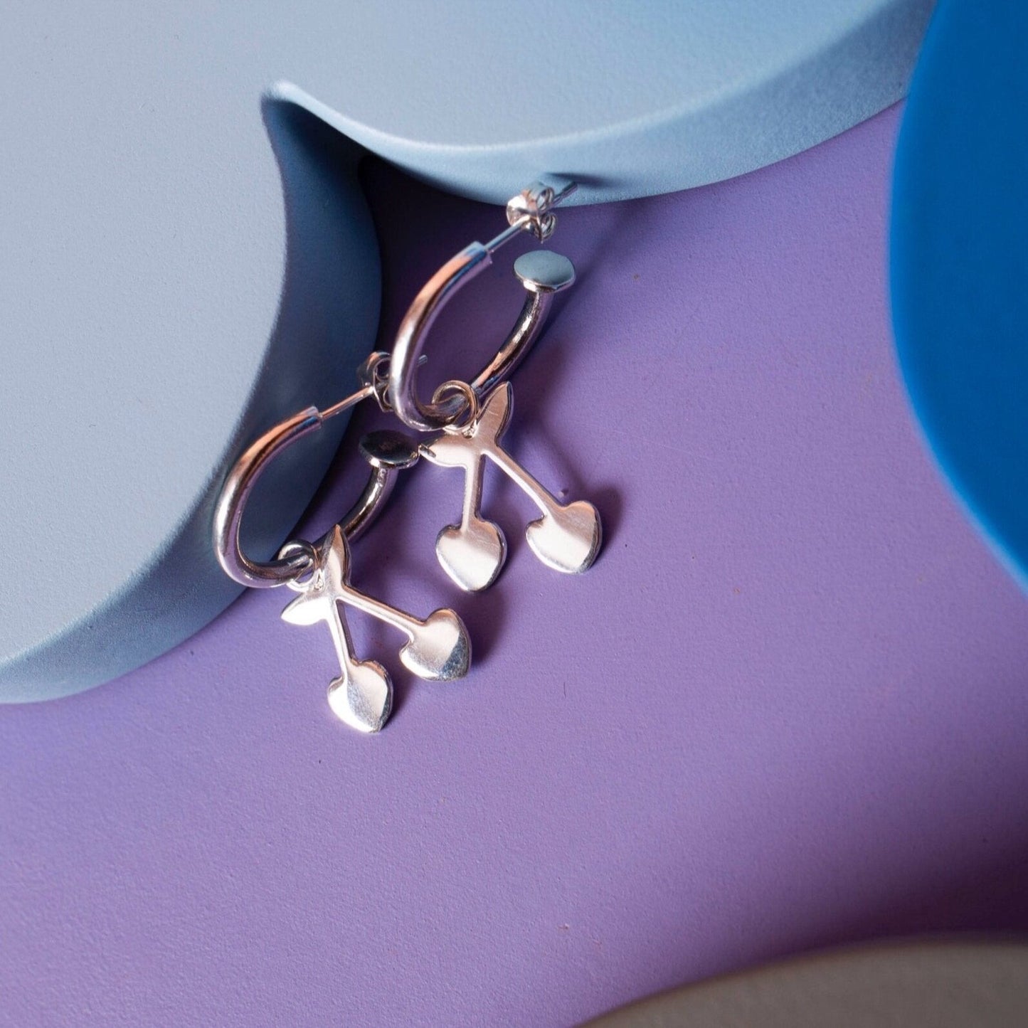 Silver hoop earrings with a cherry charm